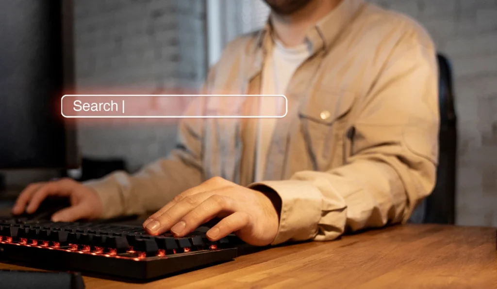 A man typing on a keyboard with "search" highlighted.