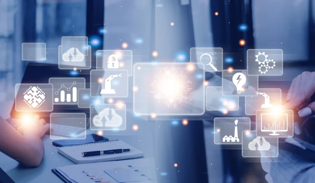 Two people sitting at a table, looking at a screen displaying various icons.