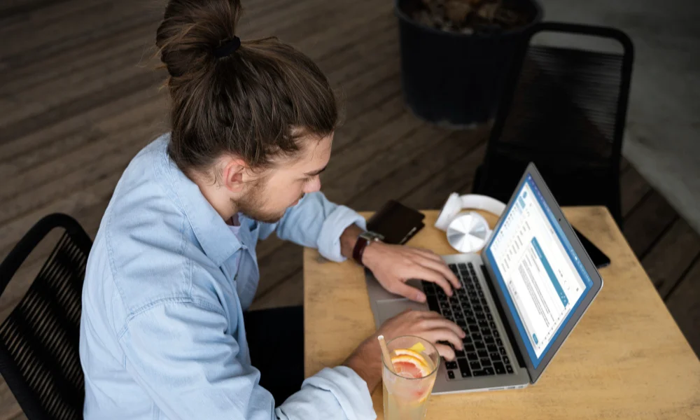 A man with long hair in a bun types on a laptop-why website slow